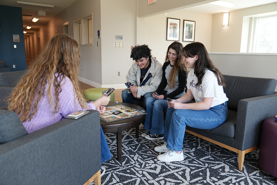 Four Converse play cards in a residential hall on campus.