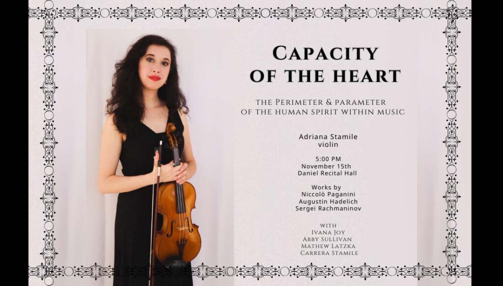 Adriana Stamile stands with her violin against a wall.